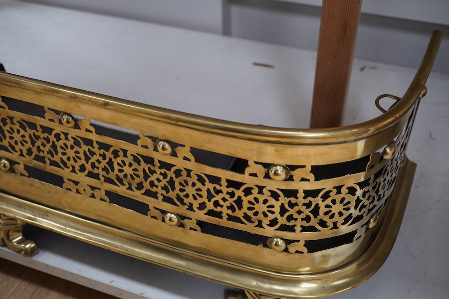 An early 19th century brass fender with pierced decoration, 91cm wide. Condition - fair to good